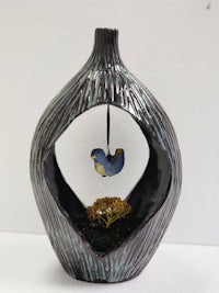 a vase with a bird in it